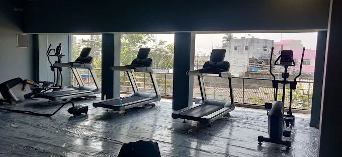 Cardio deck with treadmills and elliptical machines facing large windows