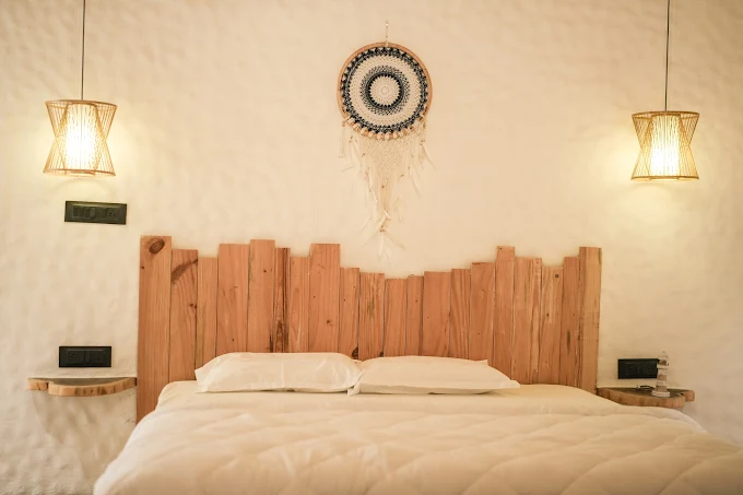 Driftwood headboard with woven dreamcatcher and pendant lighting