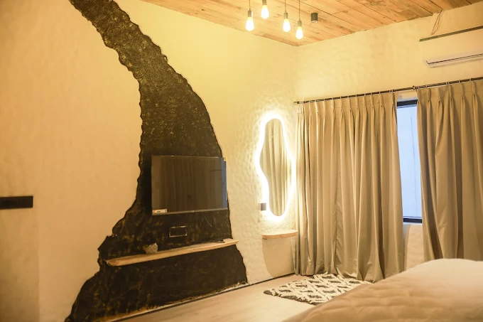 Suite with slate accent wall and mounted television
